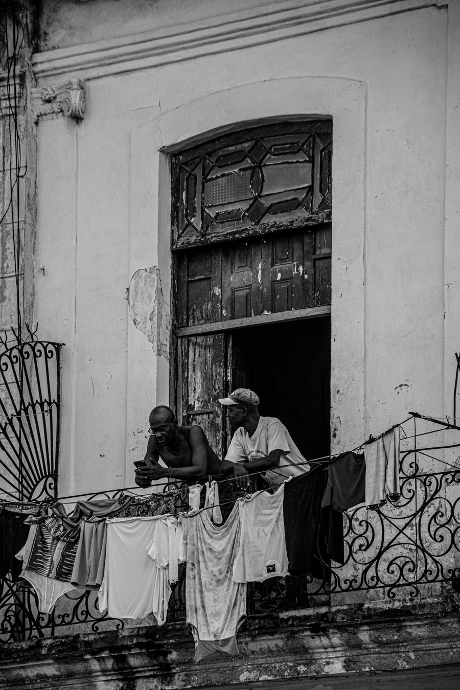 Dos hombres conversando en un balcón colonial